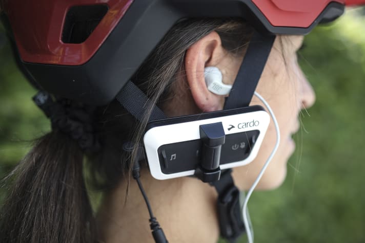 In-ear hoofdtelefoons, zoals hier op de Cardo Packtalk Outdoor, zijn niet toegestaan in het verkeer. Dankzij mesh-communicatie zijn motorrijders onafhankelijk van het mobiele netwerk.