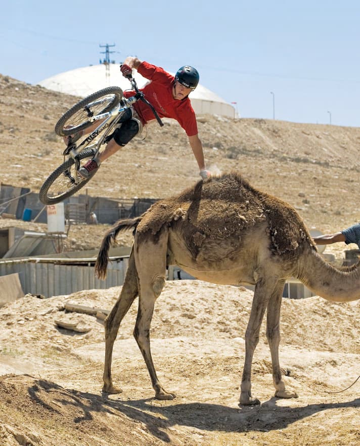 Wayne Goss flankeert over een kameel. 